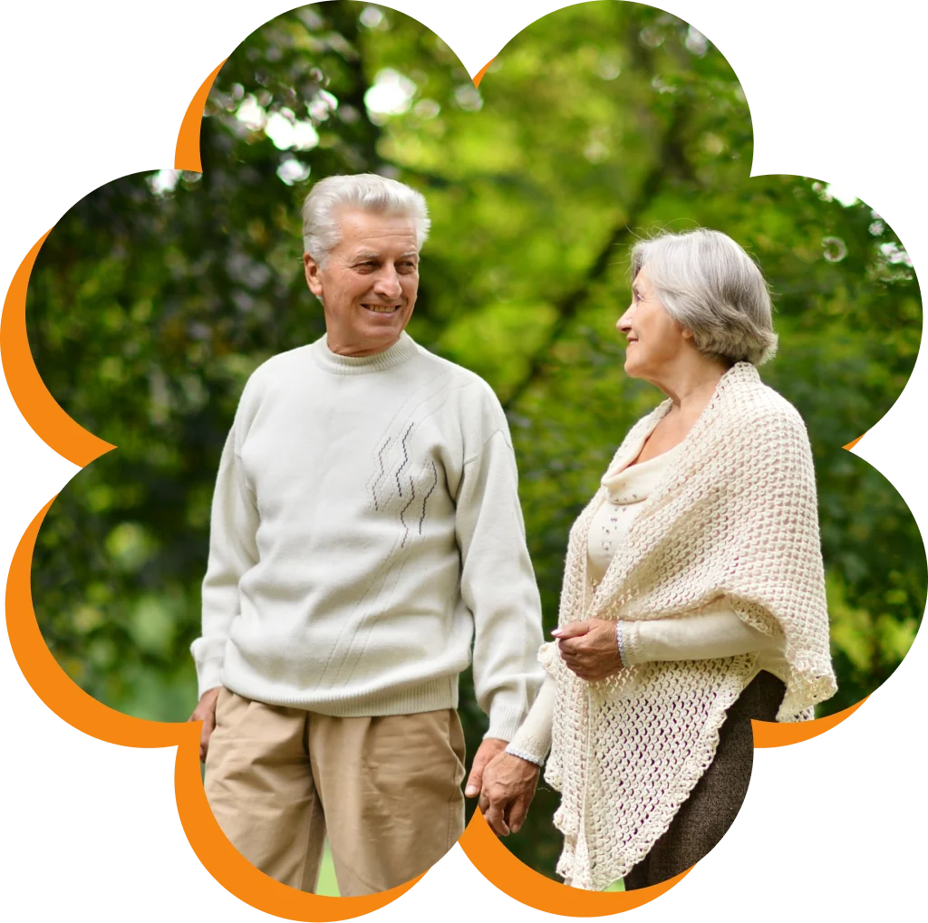 Elderly couple enjoying a walk in the park, holding hands, surrounded by green trees, in a flower-shaped frame.