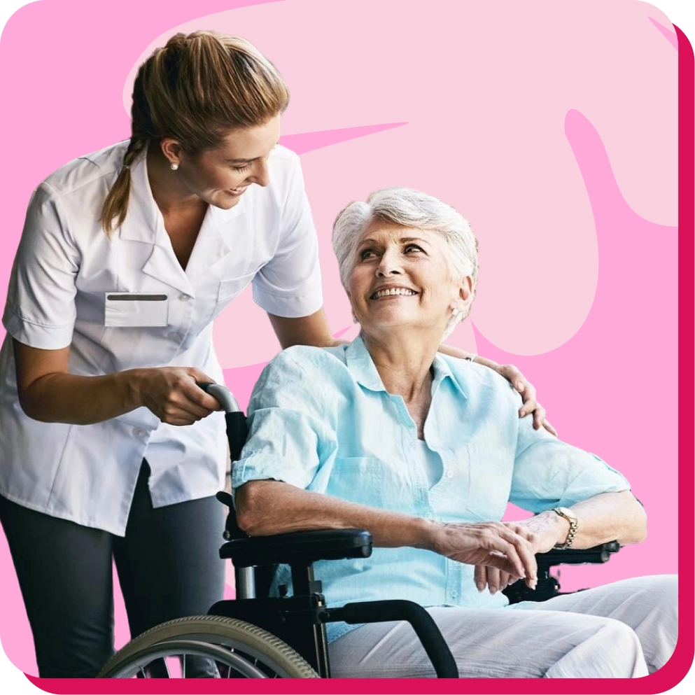 Smiling caregiver assists a senior woman in a wheelchair, set against a pink background.