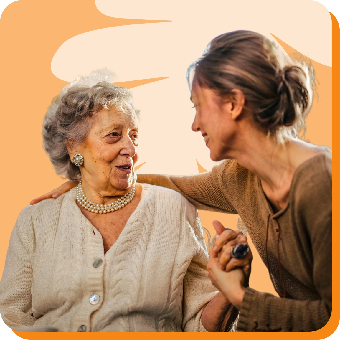 Elderly woman smiling with caregiver, engaging in a warm conversation against an orange background.