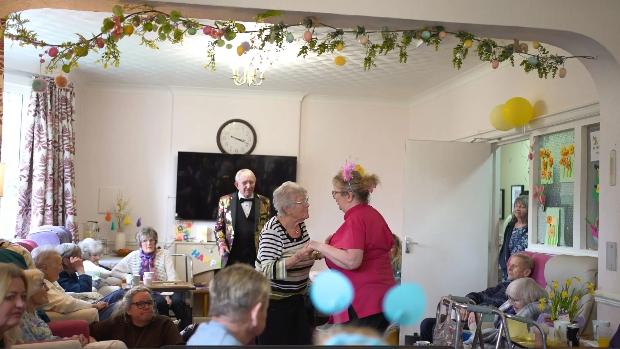 Residents enjoying an Easter celebration at a decorated senior living community room.
